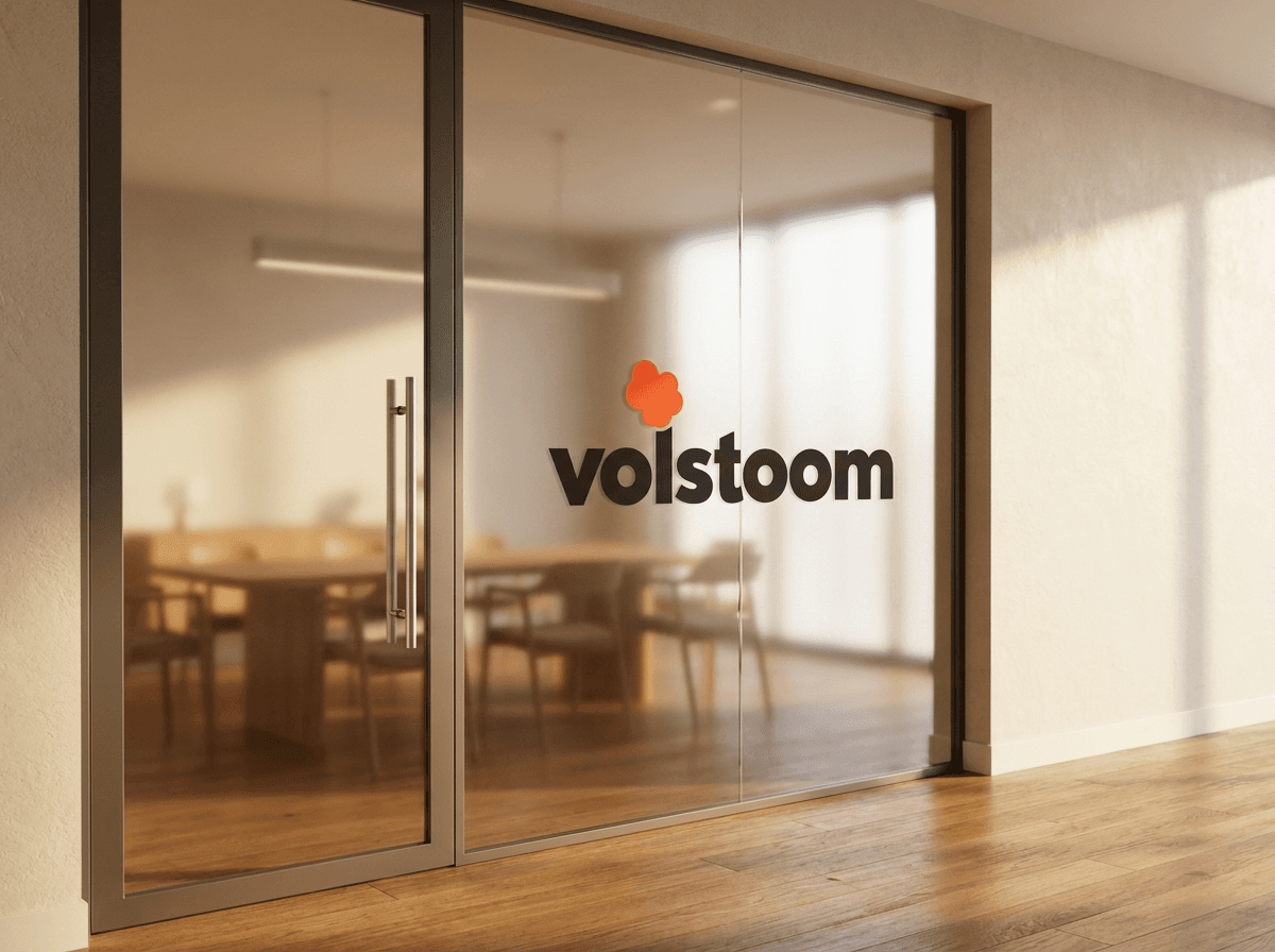 Glazen deur met het Volstoom-logo, met daarachter de vergaderruimte